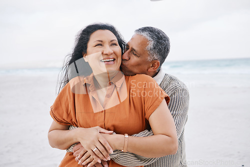 Image of Beach, hug and senior happy couple kiss, support and care on travel holiday, retirement vacation and affection in nature. Embrace, freedom and romantic elderly man, old woman or marriage people bond