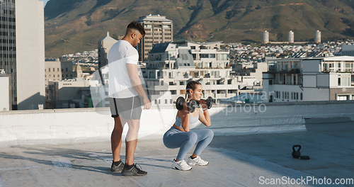 Image of Personal trainer, fitness and a woman outdoor with dumbbells for exercise, workout or training rooftop. Couple of friends in urban city for squats, strong muscle or bodybuilder and lifting weights