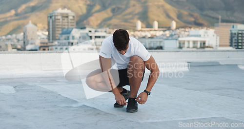 Image of City, fitness man and tie shoes lace, sneakers and start exercise, morning training or workout challenge. Rooftop footwear, wellness and outdoor athlete or person prepare for sports, health or cardio