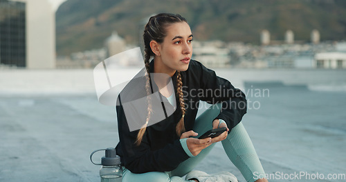 Image of Social media, fitness and woman with a phone in city for communication, health app and training. Technology, typing and girl thinking of conversation on a mobile app before doing a workout on rooftop