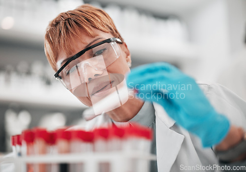 Image of Woman, science and blood sample in laboratory, ideas and analysis with ppe glasses, safety and test. Scientist, pathology and expert with thinking, check and dna data with medical research in lab