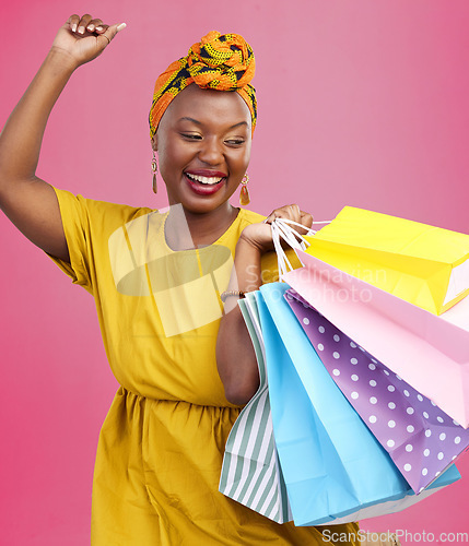 Image of Shopping, smile and black woman with bags, excited and retail on a pink studio background. African person, customer and model with luxury items, expensive clothes and boutique products with wealth