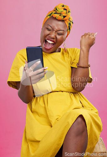 Image of Celebration, winning and black woman excited for mobile app deal isolated in studio pink background with prize. Giveaway, African and happy person with promotion, bonus and competition notification