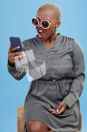 Image of Phone, news and angry black woman shocked in studio frustrated by glitch, 404 or scam on blue background. Smartphone, fail and African female model annoyed with notification, phishing or spam email