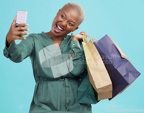 Image of Shopping bag, studio selfie and happy black woman excited for discount promotion, sales and pose for memory photo. Photography, gift and African customer post picture to online app on blue background