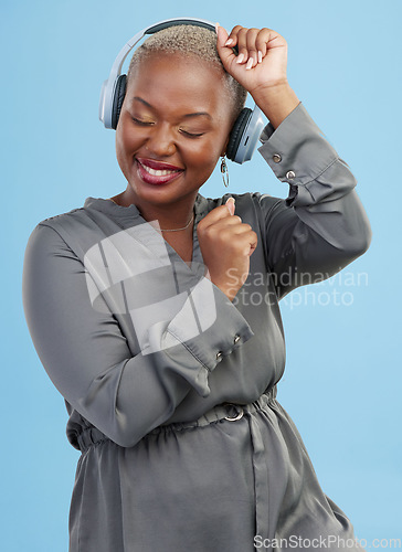 Image of Headphones, music and black woman on blue background dance for happiness, relax and chill. Happiness, technology and happy African person streaming audio, listening to radio and song in studio