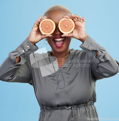 Image of Happy black woman, orange and vitamin C in diet, natural nutrition or detox against a studio background. Portrait of African female person smile with healthy organic citrus fruit for body wellness