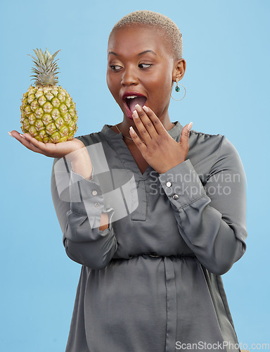 Image of Pineapple, wow and surprise with a health black woman in studio on blue background for diet or nutrition. Wellness, fruit or food with a young person looking shocked by vitamins or minerals benefits