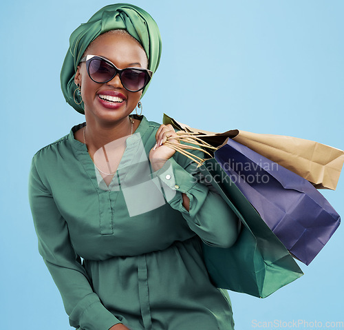 Image of Studio bag, shopping and happy customer, black woman or client excited for holiday fashion spree, sales or mall market deal. Financial freedom, retail loan and rich African person on blue background