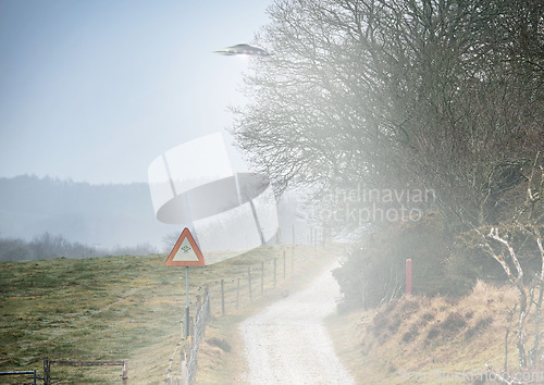 Image of UFO sign, spaceship and mist road in nature for alien warning, science fiction and abduction. Area 51, travel and signage for extraterrestrial caution in countryside, meadow and natural landscape