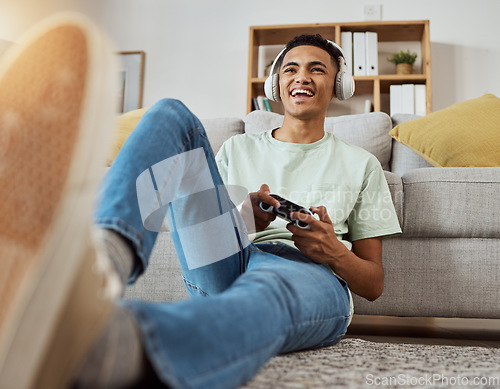 Image of Headphones, floor and man happy for video game online with controller in living room excited for virtual challenge in home. Internet, user experience and person or gamer streaming sports games