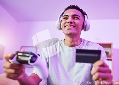 Image of Headphones, credit card and man playing video game ecommerce for purchase with controller in virtual challenge. Internet, user experience and person or esport gamer streaming sports games online