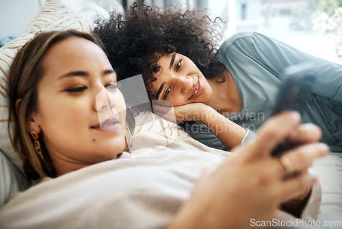 Image of Phone, social media and an lgbt couple in bed together in the morning for communication or to relax. Love, lesbian and a woman watching a movie or video with her girlfriend in the home bedroom