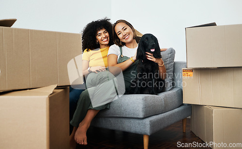 Image of Real estate, portrait and lesbian couple with a dog on the sofa for moving boxes and a new home. Smile, lgbt and women or people on the living room couch of an apartment with a pet after relocation