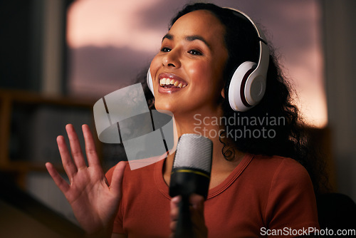 Image of Woman, headphones and microphone, radio talk show and podcast, press journalist and live broadcast at night. Happy, tech and multimedia, communication and social media streamer with content creation