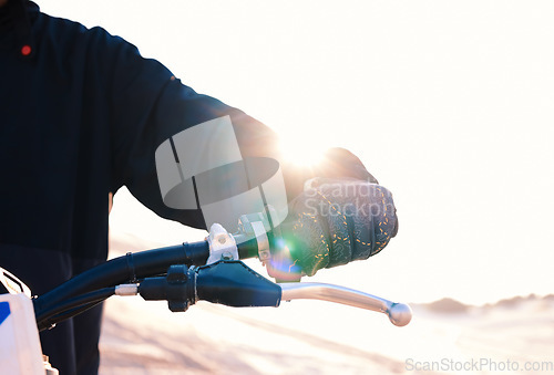 Image of Hand, bike and flare with a sports person closeup outdoor for an off ride race or competition on sand. Motorcycle, handle and control with a rider in the desert for speed, power or adrenaline