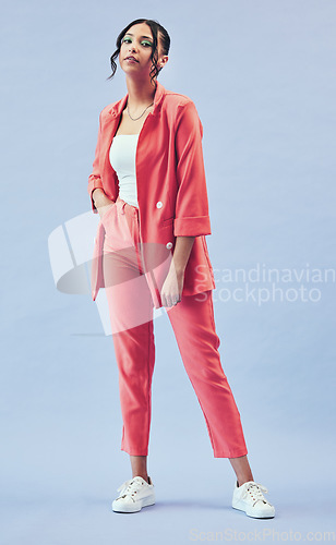 Image of Fashion, portrait and girl in suit in studio with makeup, confidence and body in outfit. Beauty, style and influencer woman in designer clothes, trendy promo and model standing on blue background.