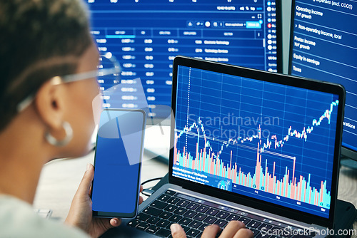 Image of Person, phone and laptop on stock market in fintech, trading or online business finance at office. Employee, broker or financial advisor on mobile smartphone or computer for profit, app or growth
