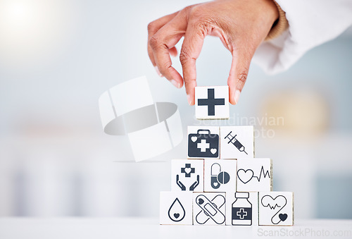 Image of Hands, healthcare and a building blocks tower in a hospital with a doctor closeup for health insurance. Medicine, icon and symbol with a medicine professional in a clinic for cardiology or treatment