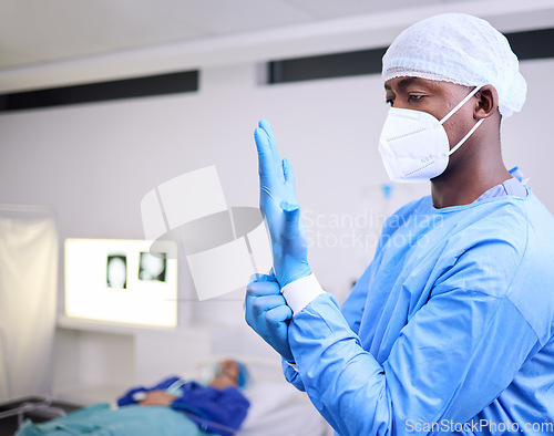 Image of Doctor, man and surgery, put glove on hand and start operation with face mask, PPE and healthcare at hospital. Surgeon ready for treatment, health and medical professional with patient for wellness