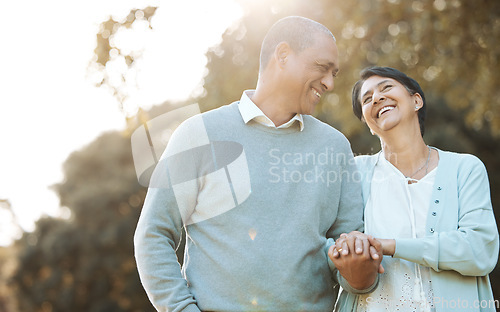 Image of Happy, love and senior couple in a park on an outdoor date for romance, bonding or love. Smile, talking and elderly man and woman in retirement in conversation walking in a field together at sunset.