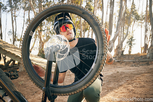 Image of Nature, man and bike with tire repair, wheel change or maintenance on broken bicycle in forest for workout. Person, cycling and inspection before exercise, training or adventure in woods or path