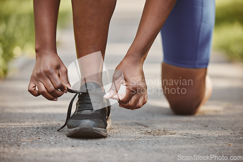 Image of Person, hands and tie shoes in fitness getting ready running exercise or outdoor cardio workout. Closeup of athlete or runner tying shoe on asphalt in preparation for training or run at the park