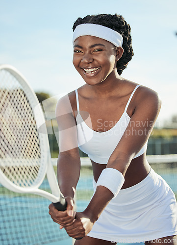 Image of Fitness, portrait and woman tennis player with a racket practicing to play a match at stadium. Sports, smile and professional African female athlete with equipment training on court for tournament.