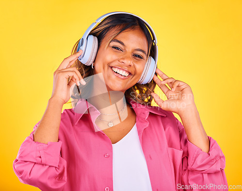 Image of Woman, headphones and listen to music in portrait, happiness and entertainment on yellow background, Fun, audio streaming and radio with rave or techno in studio, student with wireless tech and smile