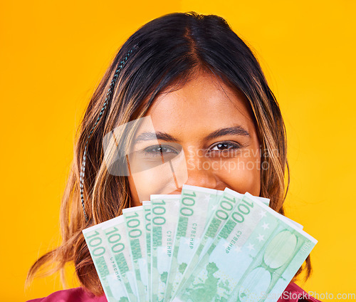 Image of Woman, eyes and cash fan by face, financial freedom and wealth with winning bonus on yellow background. Money, finance with reward or prize from giveaway in studio, winner in portrait with cashback