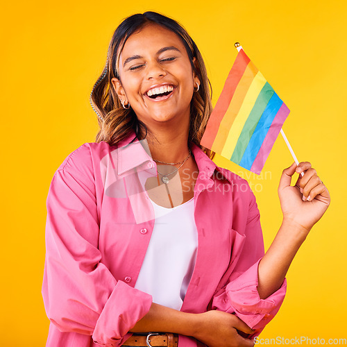 Image of Happy woman, pride and flag with rainbow and LGBTQ community in studio, equality and celebration on yellow background. Freedom to love, support with lesbian or ally, gen z student with gay identity