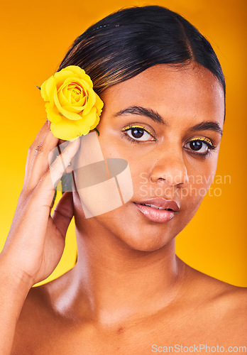 Image of Skincare, flower and portrait of woman in studio with beauty, glow and cosmetic face routine. Makeup, rose and young female model from Mexico with facial treatment isolated by yellow background.