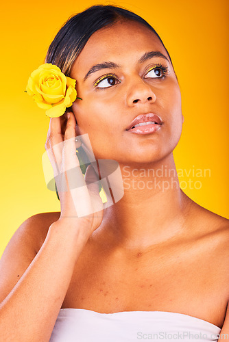 Image of Skincare, flower and young woman in studio with cosmetic, glow and beauty face routine. Dermatology, floral rose and female model from Mexico with facial skin treatment isolated by yellow background.