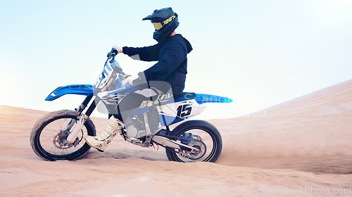 Image of Dirt, motorbike and athlete or man in sports, adventure and driving on desert, sand dune and outdoor riding in nature. Extreme sport, bike or motorcycle drive with helmet, gear or person with freedom