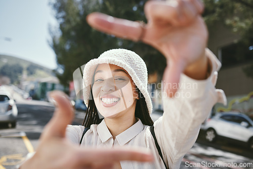 Image of Happy woman, portrait and frame in city for photography, fashion or outdoor memory in selfie. Female person smile with hands framing face for photograph, picture or social media tour in urban town