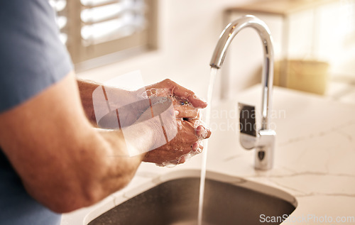Image of Closeup, water and washing hands in bathroom for hygiene, wellness or disinfection for health. Soap, man and cleaning skin to remove bacteria, virus germs and dirt for safety or protection in home