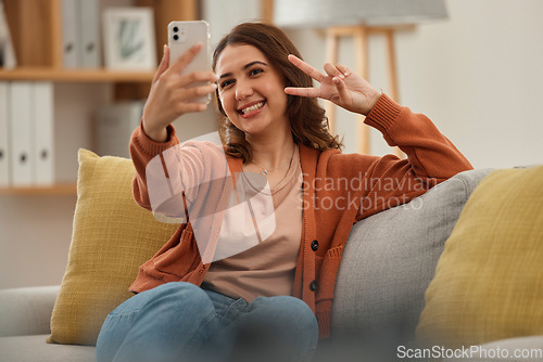 Image of Selfie, peace hand sign and woman on couch, social media post with influencer at home and memory. Smile in picture for content creation, mobile app and relax in living room, V emoji and photography