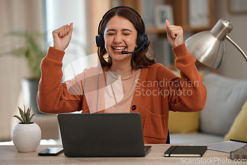 Image of Woman, headset and laptop in celebration at home with goal, achievement and victory. Female person, consultant or employee with arms up in happiness on video call, telemarketing or support to clients