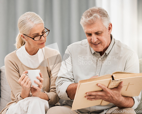 Image of Bible, reading and senior couple in a living room with book for gospel, discussion or learning in their home. God, worship and elderly man with old woman enjoy retirement with holy, praise or faith