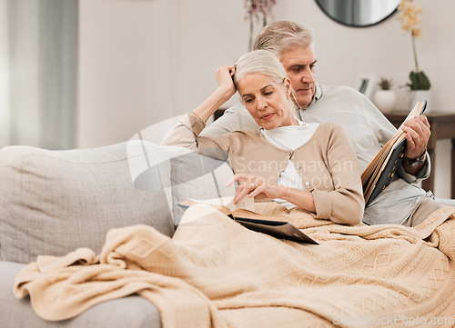 Image of Old couple on couch, reading book and relax together at home, retirement and wellness with love and comfort. Trust, care and support in marriage, share hobby with partner for knowledge and story