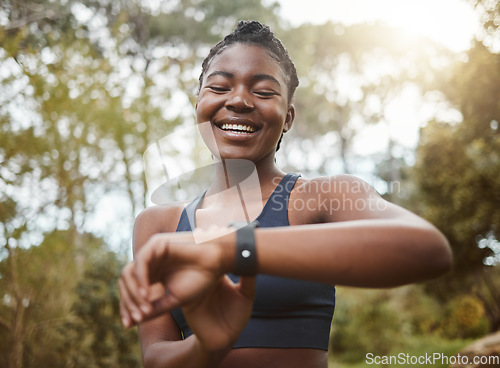 Image of African runner woman, smart watch and park for check, smile or happy for time, results or fitness in nature. Girl, iot clock and monitor for speed, heart rate or smile for exercise, workout or health