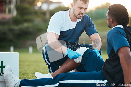 Image of Sports, injury and man with bandage for accident, emergency and first aid for muscle sprain on field. Fitness, healthcare and medic with athlete with knee pain from exercise, workout and training