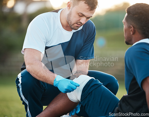Image of Sports, injury and man on field with bandage for accident, emergency and first aid for muscle sprain. Fitness, healthcare and medic with athlete with knee pain from exercise, workout and training