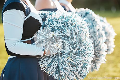 Image of Cheerleader team, sports and hands with pompom for dance, performance and motivation for game. Teamwork, dancer and people in costume cheering for support in match, competition and event outdoors