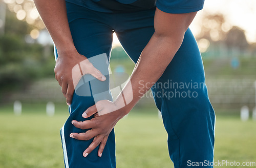 Image of Sports, injury and person on field with knee pain for accident, emergency and joint ache for muscle sprain. Fitness, healthcare and hands of athlete with strain from exercise, workout and training