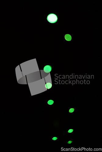 Image of Green light, bokeh and glow on dark background isolated on a mockup space. Blur, black backdrop and defocused shine, sparkle or glitter at night for Christmas, holiday or party with magic color dots