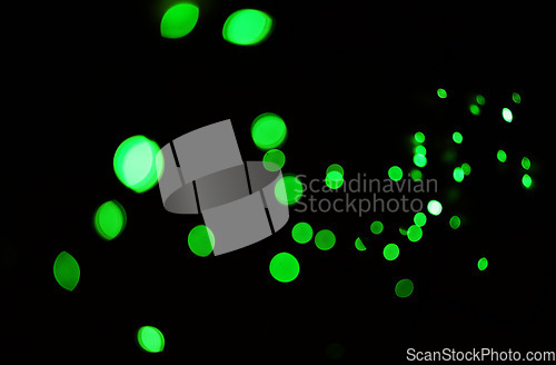 Image of Green light, bokeh and glow on dark background isolated on a mockup space. Blur, black backdrop and defocused shine, sparkle or glitter at night for Christmas, holiday or party with magic color dots