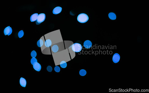 Image of Blue, confetti and bokeh in a studio with dark background for celebration, event or party. Lights, glitter and color sparkles for magic, shine or glow for festive by black backdrop with mockup.