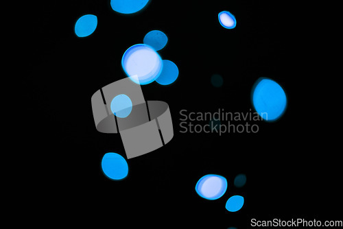 Image of Bokeh, blue particles and dots on dark background with pattern, texture and mockup with cosmic aesthetic. Night lighting, sparkle lights and glow on black wallpaper with space, color shine and flare.