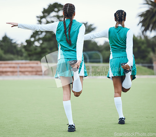 Image of Hockey, sports or team stretching legs in training, practice or fitness workout exercise on turf together. Teamwork, back or healthy athletes women with flexibility ready to start a game in warm up